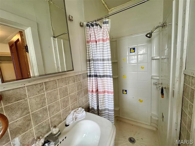 full bathroom featuring a shower stall and tile walls