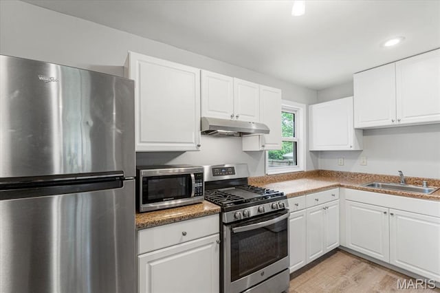 284 Ramsey Ln, Ballwin, MO 63021 - kitchen with appliances with stainless steel finishes, under cabinet range hood, a sink, white cabinetry, and recessed lighting