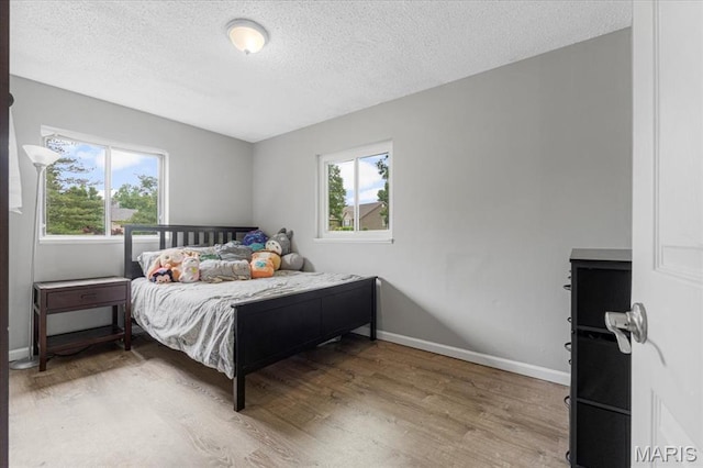 284 Ramsey Ln, Ballwin, MO 63021 - bedroom featuring wood finished floors, a textured ceiling, and baseboards