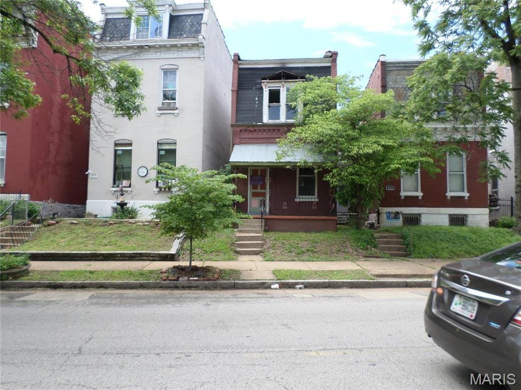 victorian home with a porch and mansard roof