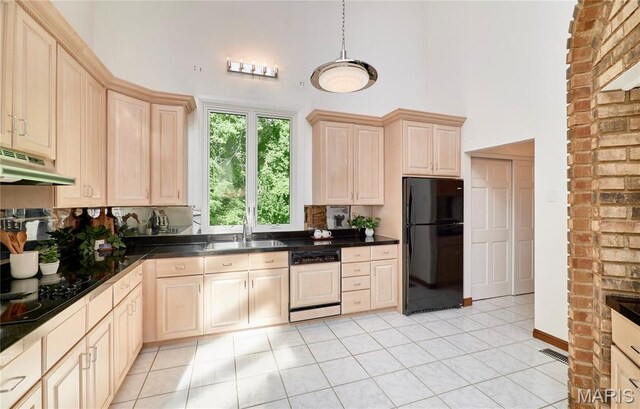 14424 Valley Meadow Ct W, Chesterfield, MO 63017 - kitchen with freestanding refrigerator, a towering ceiling, dishwasher, under cabinet range hood, and dark countertops