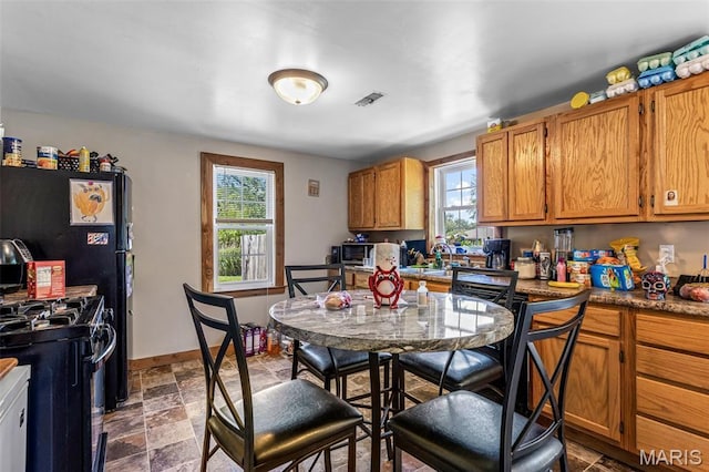 1158 Mulberry St, Bismarck, MO 63624 - kitchen featuring black range with gas cooktop, a sink, stainless steel microwave, brown cabinets, and dark stone finish floors