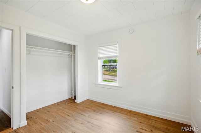 402 N 11th St, De Soto, MO 63020 - unfurnished bedroom featuring light wood-type flooring, a closet, and baseboards