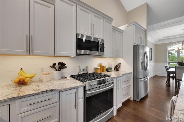 2 Mahogany Run, Farmington, MO 63640 - kitchen with appliances with stainless steel finishes, dark wood-style flooring, decorative backsplash, a wainscoted wall, and light stone countertops