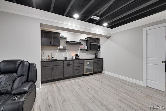 2 Mahogany Run, Farmington, MO 63640 - indoor wet bar featuring beverage cooler, stainless steel microwave, light wood finished floors, crown molding, and baseboards