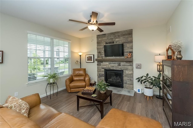 17006 Main St, Wildwood, MO 63040 - living area featuring a ceiling fan, wood finished floors, a stone fireplace, and baseboards