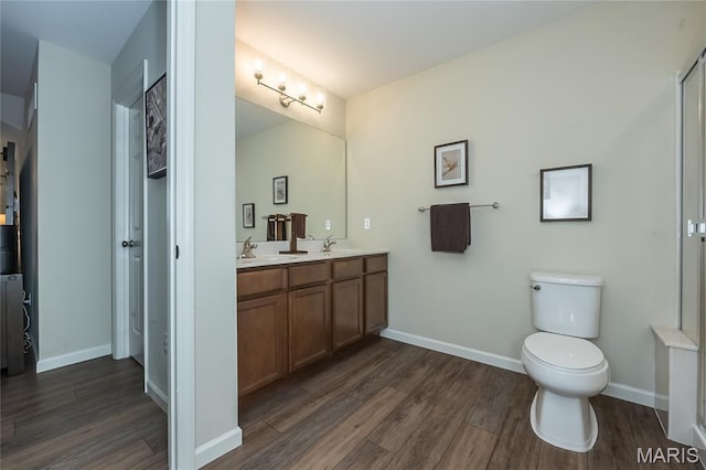 17006 Main St, Wildwood, MO 63040 - bathroom featuring wood finished floors, double vanity, baseboards, and toilet