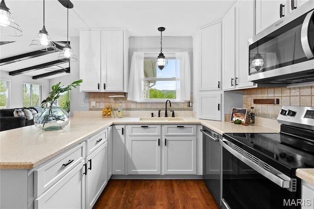 827 Bridgewater Xing, Villa Ridge, MO 63089 - kitchen with stainless steel appliances, a sink, a peninsula, white cabinetry, and hanging light fixtures