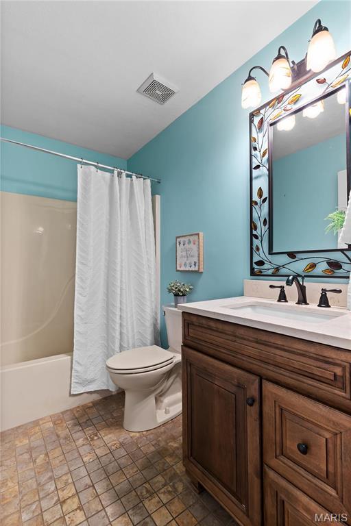 827 Bridgewater Xing, Villa Ridge, MO 63089 - full bath with toilet, vanity, stone finish floors, and shower / tub combo with curtain
