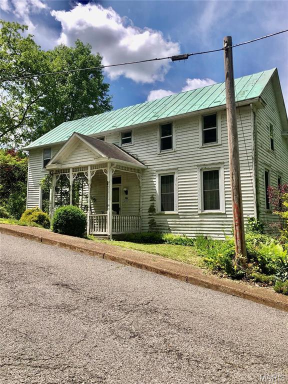 view of front of property featuring a standing seam roof, a porch, and metal roof