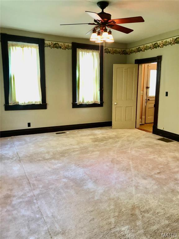 empty room featuring baseboards and a ceiling fan