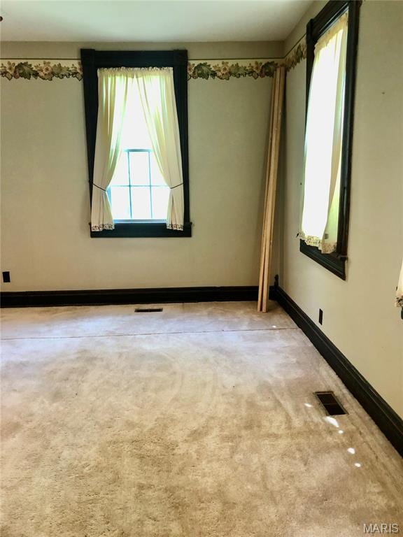 carpeted spare room featuring baseboards