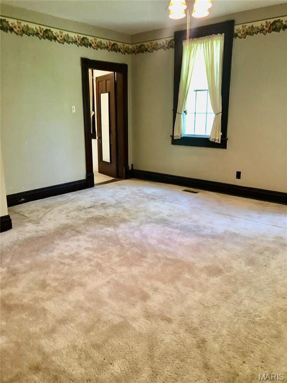 carpeted empty room featuring baseboards