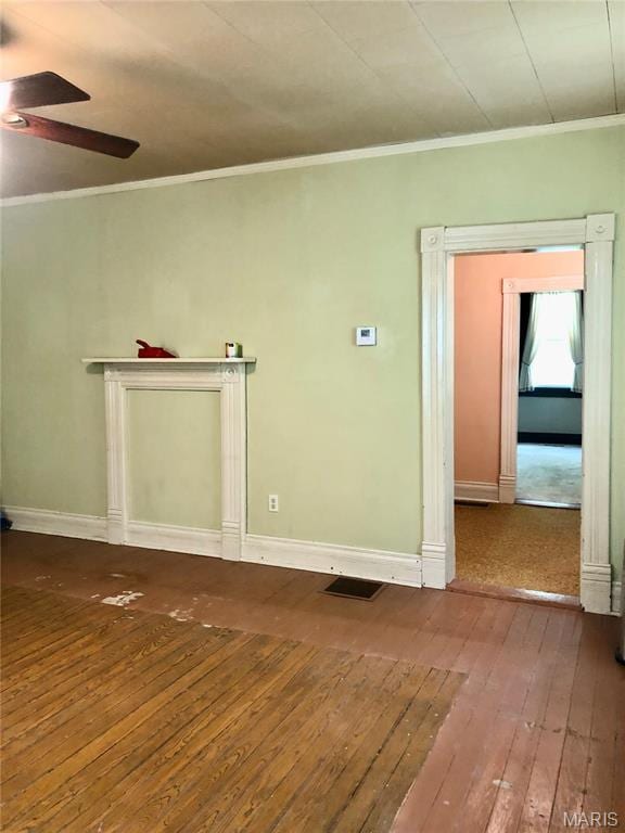 spare room with wood-type flooring, ceiling fan, ornamental molding, and baseboards