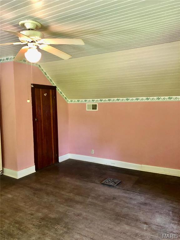 bonus room featuring baseboards, a ceiling fan, vaulted ceiling, and dark wood finished floors