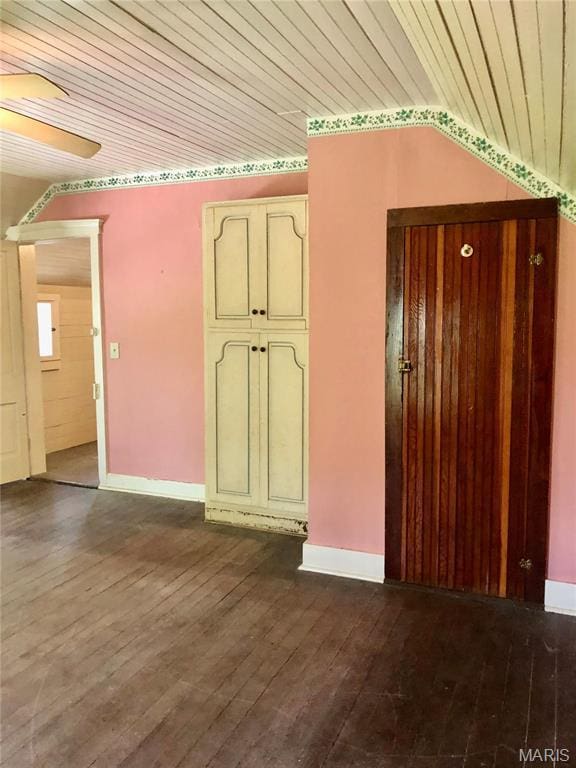 spare room with wooden ceiling, dark wood-style floors, baseboards, and a ceiling fan