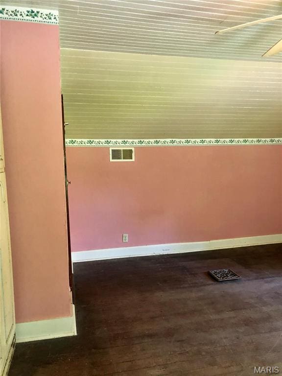 unfurnished room featuring baseboards and dark wood finished floors