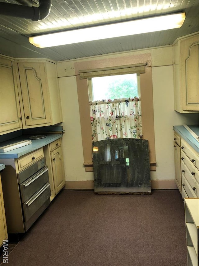 kitchen with dark colored carpet and baseboards