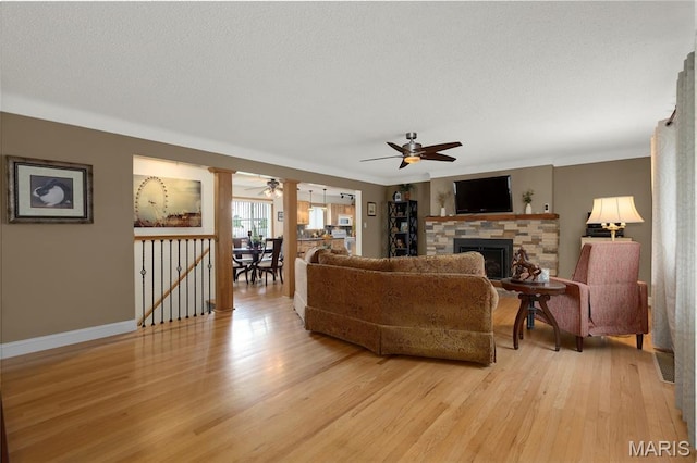 1261 Whispering Winds Dr, Arnold, MO 63010 - living area with ceiling fan, light wood-type flooring, a fireplace, and a textured ceiling