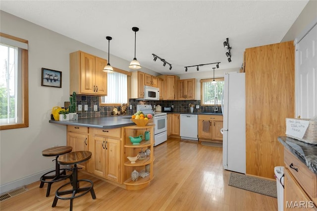 1261 Whispering Winds Dr, Arnold, MO 63010 - kitchen featuring white appliances, dark countertops, a peninsula, and tasteful backsplash