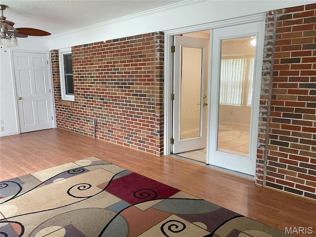 408 Crestview St, Cuba, MO 65453 - interior space with wood finished floors, a ceiling fan, ornamental molding, and brick wall