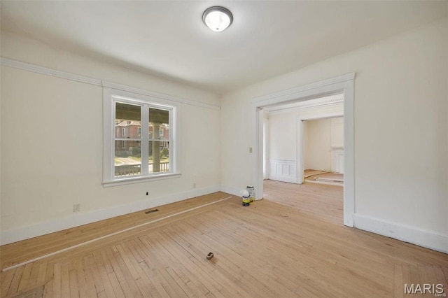 empty room with light wood finished floors and baseboards