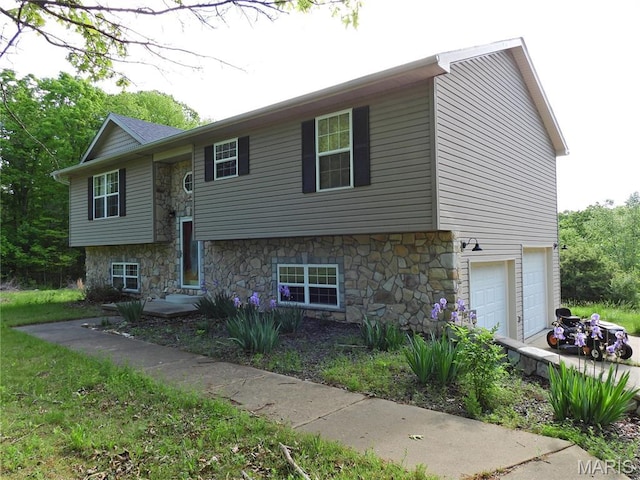 split foyer home with stone siding and an attached garage