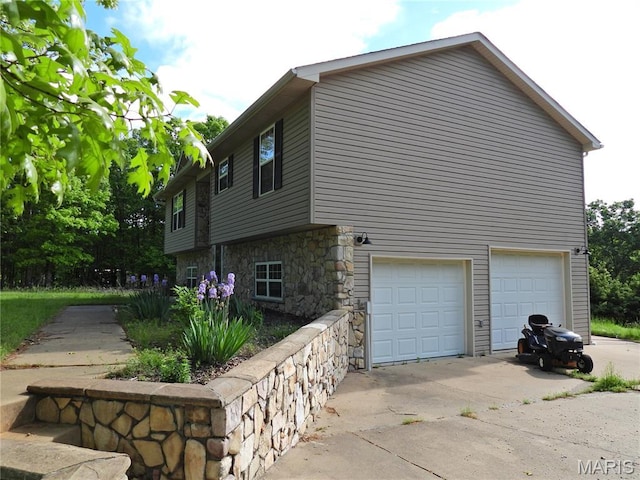 view of property exterior with stone siding, driveway, and an attached garage