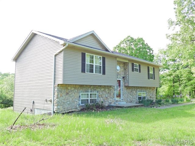 raised ranch featuring stone siding and a front lawn