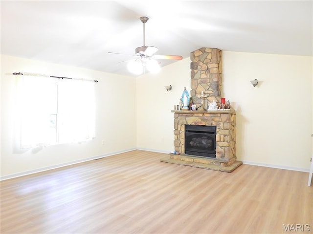 unfurnished living room featuring light wood finished floors, lofted ceiling, a ceiling fan, a fireplace, and baseboards