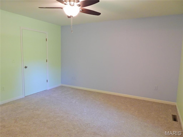 carpeted empty room with a ceiling fan and baseboards