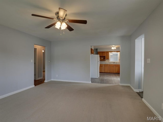 324 E Olive St, Palmyra, MO 63461 - unfurnished living room featuring ceiling fan, light carpet, baseboards, and a sink
