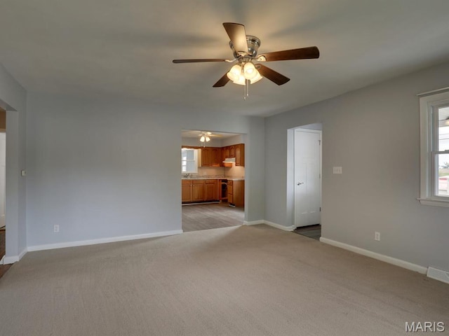 324 E Olive St, Palmyra, MO 63461 - unfurnished living room featuring ceiling fan, light colored carpet, and baseboards