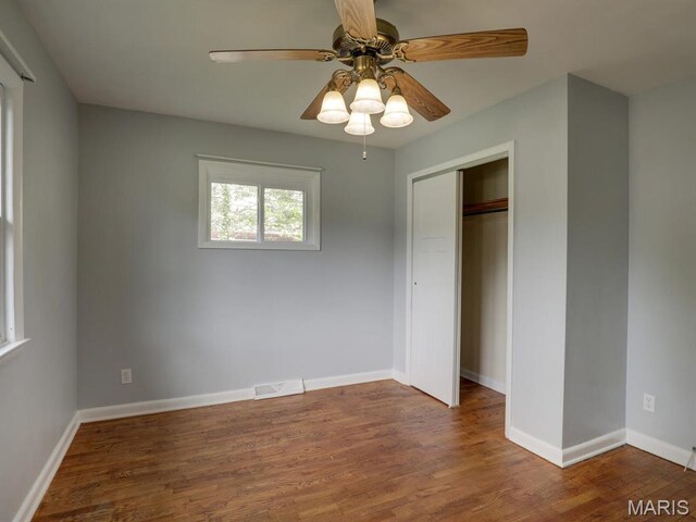 324 E Olive St, Palmyra, MO 63461 - unfurnished bedroom with wood finished floors, a closet, baseboards, and a ceiling fan