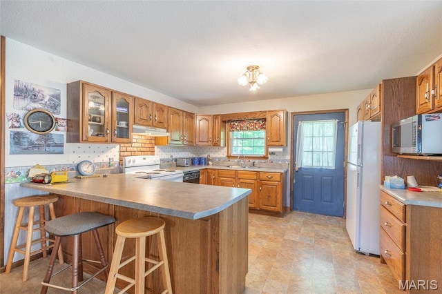 127 Chippewa, Piedmont, MO 63957 - kitchen with white appliances, a peninsula, brown cabinets, a breakfast bar area, and a sink