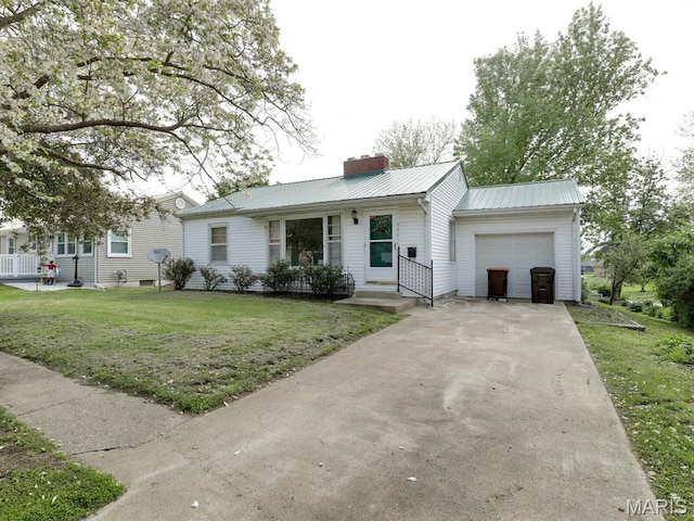 ranch-style home featuring an attached garage, a chimney, metal roof, a front yard, and concrete driveway