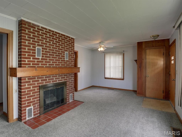 unfurnished living room with carpet flooring, crown molding, ceiling fan, a brick fireplace, and baseboards