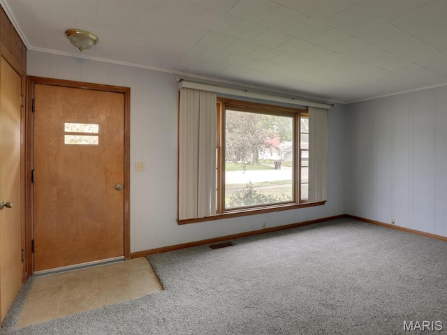 carpeted entryway with crown molding and baseboards