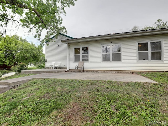 back of property with a patio area and a yard
