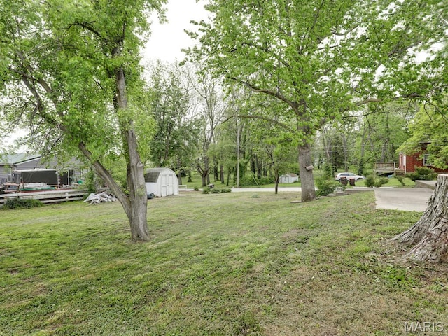 view of green lawn featuring a shed and an outbuilding