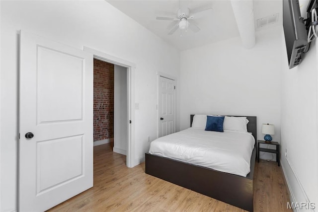2765 Caroline St, Saint Louis, MO 63104 - bedroom with light wood-style floors, baseboards, beam ceiling, brick wall, and ceiling fan