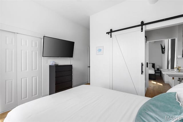 2765 Caroline St, Saint Louis, MO 63104 - bedroom with a barn door, wood finished floors, and a closet