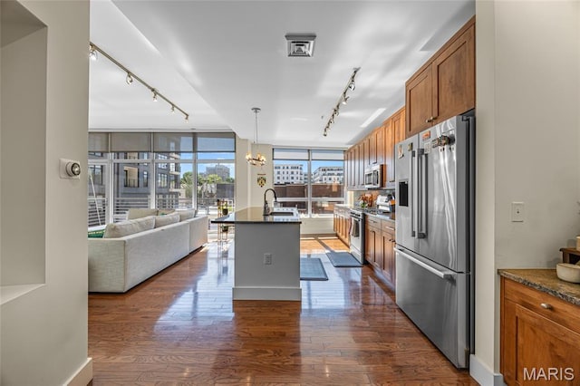 9 N Euclid Ave Unit 303, Saint Louis, MO 63108 - kitchen featuring rail lighting, high quality appliances, brown cabinetry, open floor plan, and dark wood-style flooring