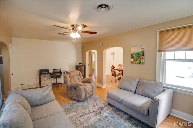 931 Sugarloaf Hill Rd, Dupo, IL 62239 - living room featuring arched walkways, a ceiling fan, light wood-style flooring, and baseboards