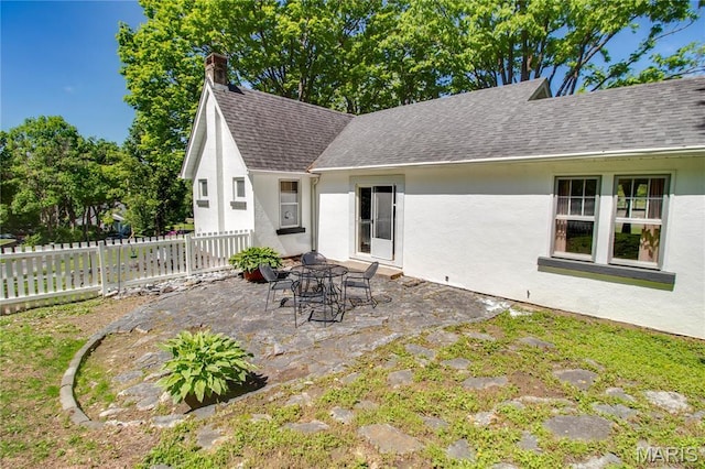 931 Sugarloaf Hill Rd, Dupo, IL 62239 - back of property featuring stucco siding, fence, a patio area, a shingled roof, and a chimney