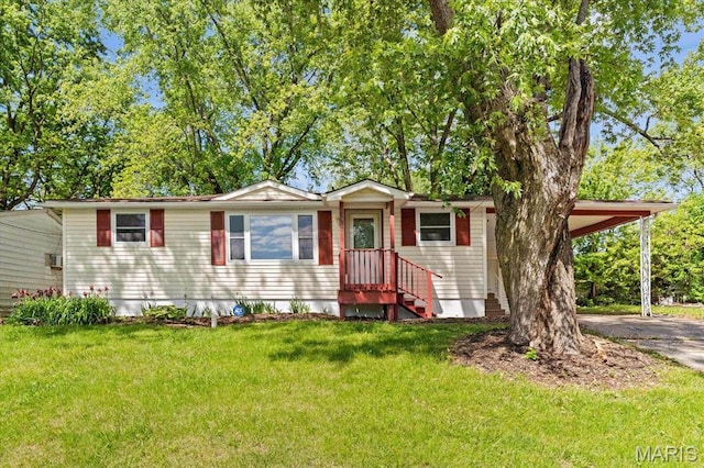 view of front of home with an attached carport, a front yard, and asphalt driveway