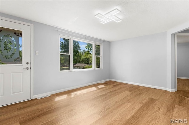 foyer with light wood finished floors and baseboards