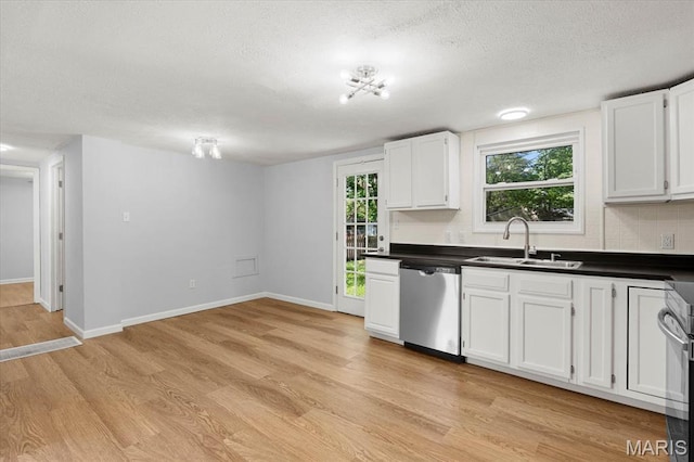 kitchen with dishwasher, a sink, a textured ceiling, light wood-type flooring, and dark countertops