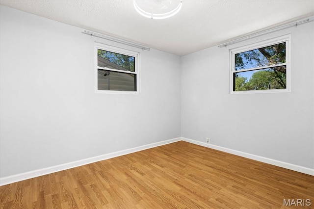 spare room with light wood finished floors and baseboards