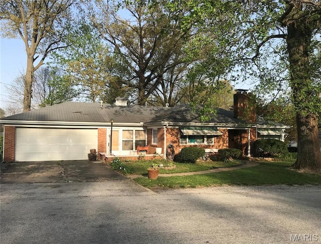 245 Oliver Lee Dr, Belleville, IL 62223 - ranch-style house with a chimney, driveway, brick siding, and an attached garage
